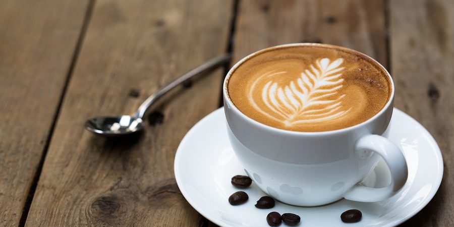 Cup of hot latte art coffee on wooden table